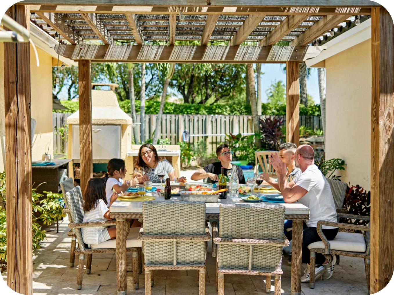 Family enjoying outdoor meal under pergola