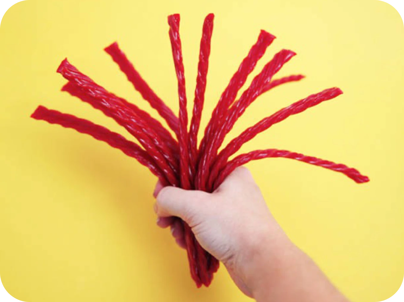 Hand holding red licorice sticks