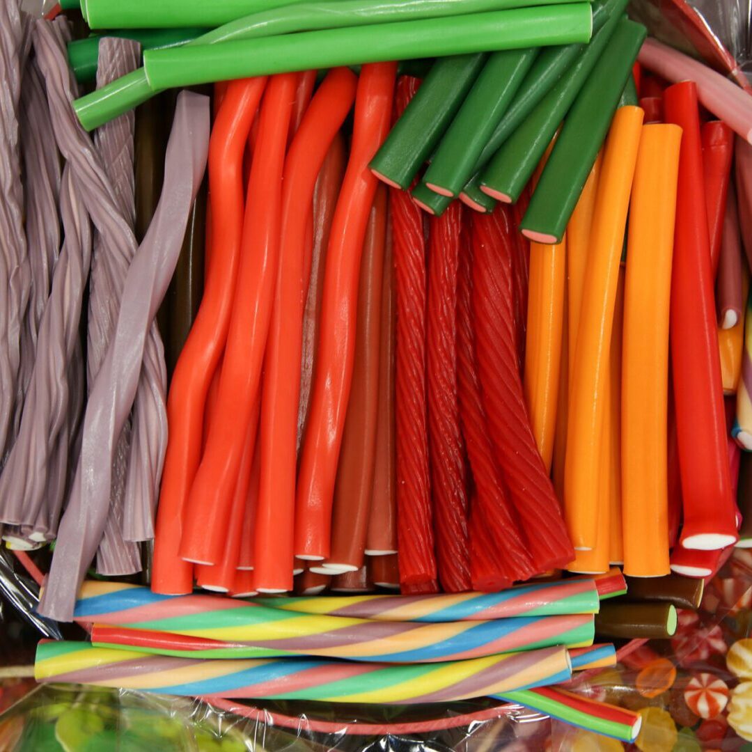 Colorful assorted candy sticks and licorice piled together.